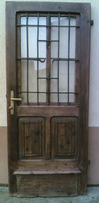 Porta a battente con griglia di ferro.